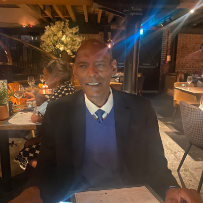 Donald Newman at dinner in suit and tie.