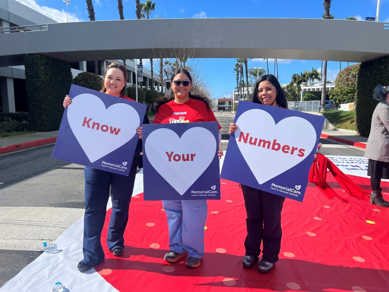 women holding "know your numbers" signs.