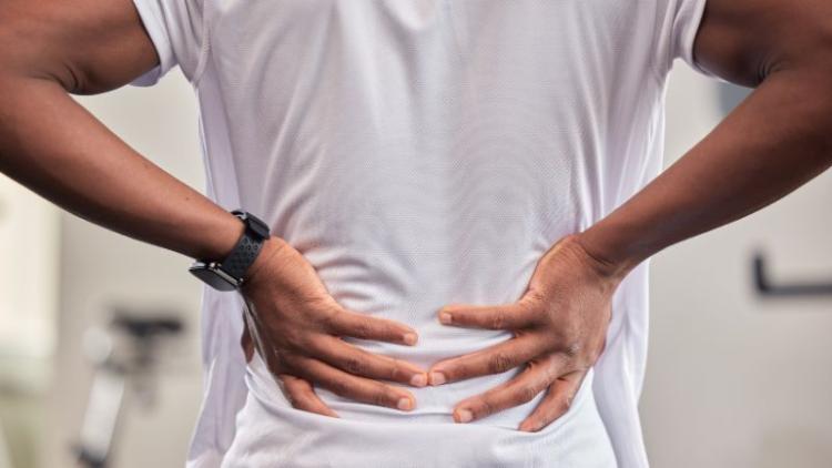 A person holding their lower back in pain.