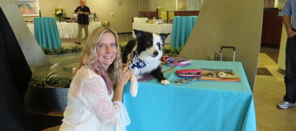 Image of surfboard artist Kimberley Hansler. The board featured one of Orange Coast Medical Center's therapy dogs, Kiss, riding a wave.