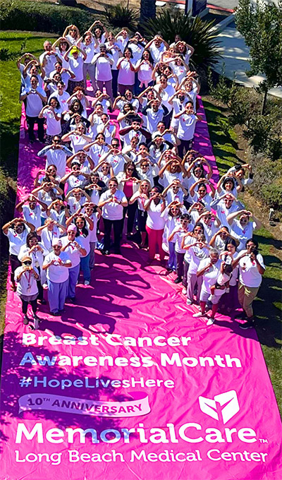More than 100 employees, physicians, patients, and elected officials create a giant human awareness ribbon for breast cancer awareness month.